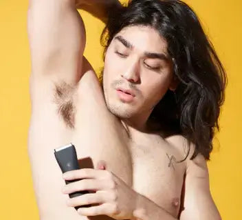 man using body groomer to trim underpit hair